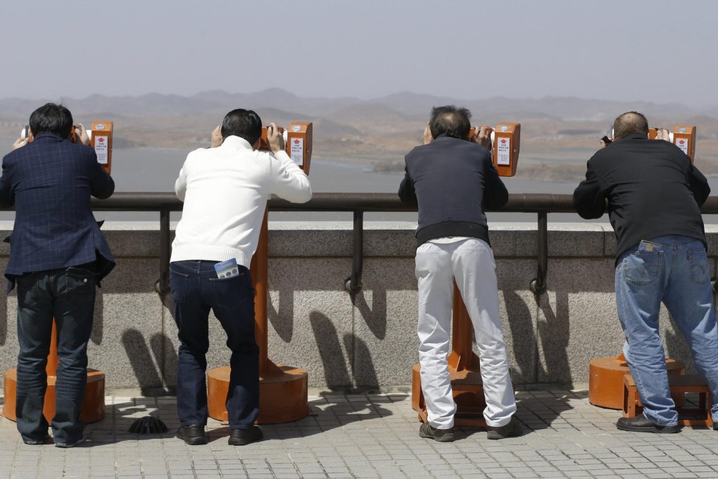 Visitors to an observation post in Paju, near the border village of Panmunjom, use binoculars yesterday to look into North Korea. Photo: AP