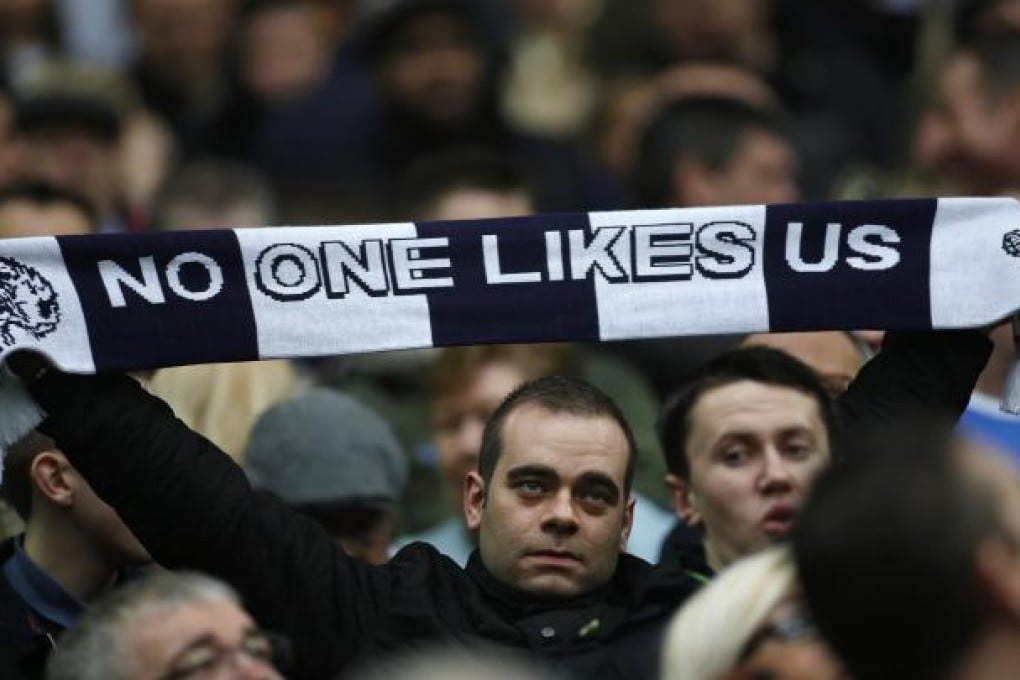 A Millwall fan holds up a scarf in the stands before the start of their FA Cup semi-final match against Wigan Athletic at Wembley Stadium. A bloody fight that broke out afterwards caused children to cry. Photo: AP