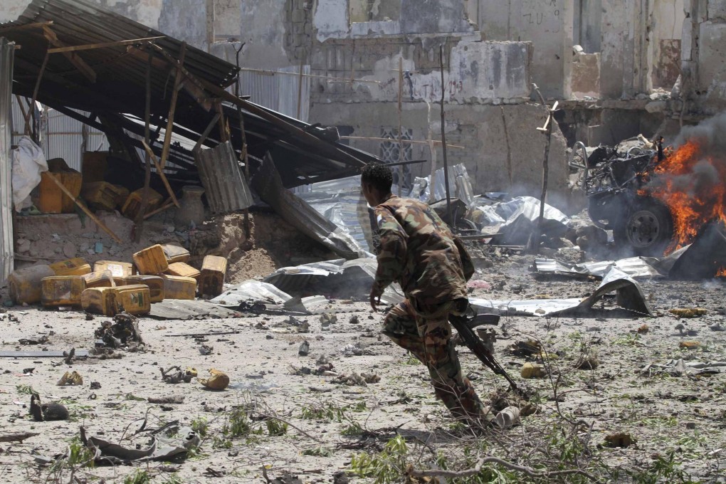 A Somali soldier runs near the scene of the blast which struck outside the law courts in Mogadishu yesterday. Photo: Reuters