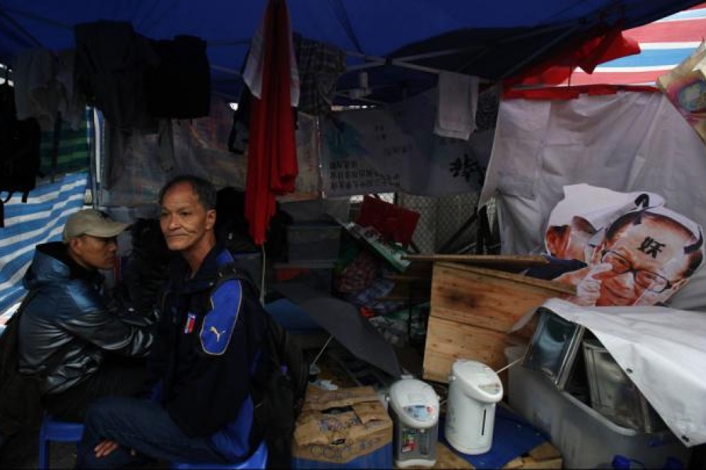 Dock workers sit inside a tent beside a paper cutout of Hong Kong tycoon Li Ka-shing during a strike outside Kwai Chung container terminal. Photo: Reuters