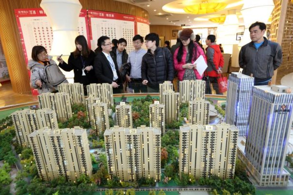 Visitors look at a model of residential buildings at the Fun City apartment complex, developed by China Vanke. Photo: Bloomberg