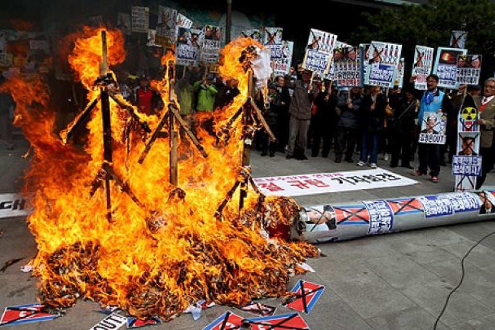 South Korean activists burn effigies of North Korea's founder, the late Kim Il-sung, late leader Kim Jong-il and leader Kim Jong-un during a rally in Seoul on Monday. Photo: EPA