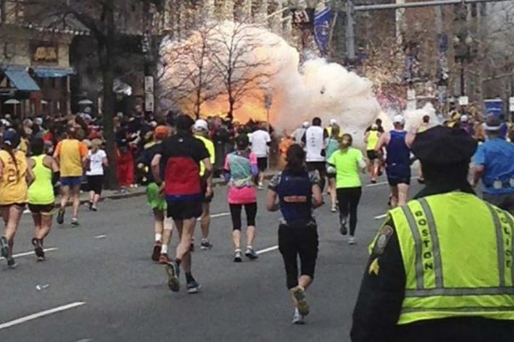 Runners approach the finishing line in the Boston Marathon as a bomb goes off, sending up a huge cloud of smoke. Photo: Reuters
