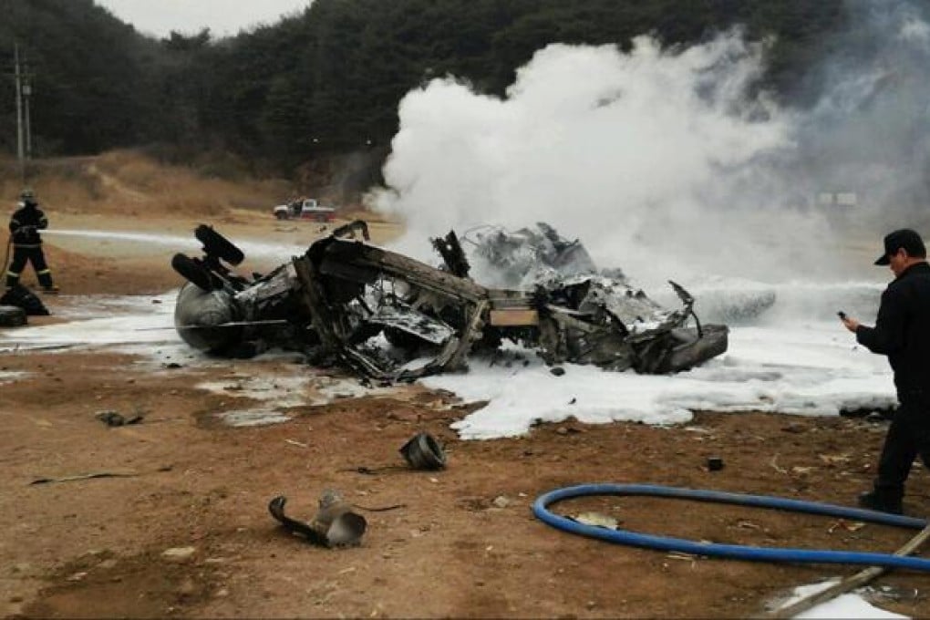 South Korean firefighters douse the wreckage of the CH-53 US Marine Corps helicopter yesterday on a training field in Cheolwon. Photo: AFP