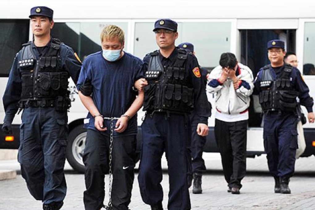 Two men suspected of planting suitcases loaded with petrol on a high-speed train in Taiwan are escorted to Taiwan's Criminal Investigation Bureau in Taipei on Tuesday after their extradition from China. Photo: AFP