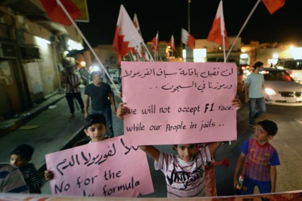 Children hold anti-F1 placards in a village near Manama. Photo: EPA