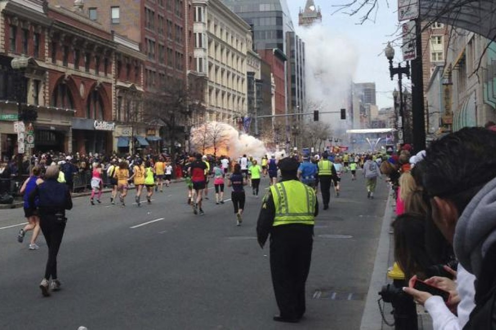 Runners continue to run towards the finish line as an explosion erupts at the finish line of the Boston Marathon. Photo: Reuters