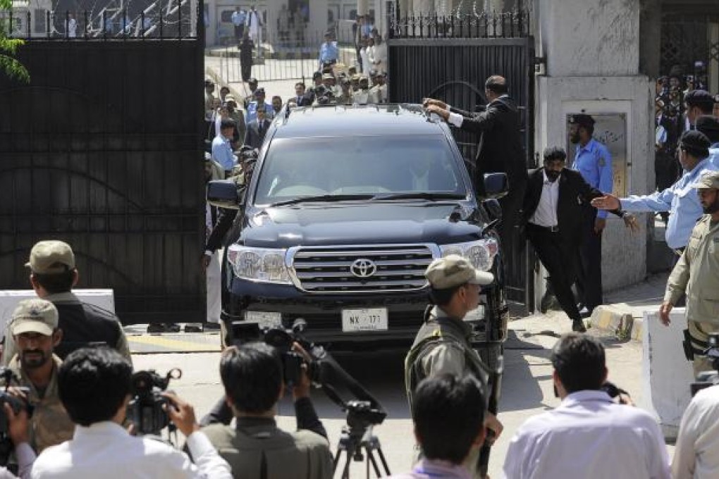 Bodyguards rush former military ruler Pervez Musharraf from the High Court in Islamabad. Photo: AP