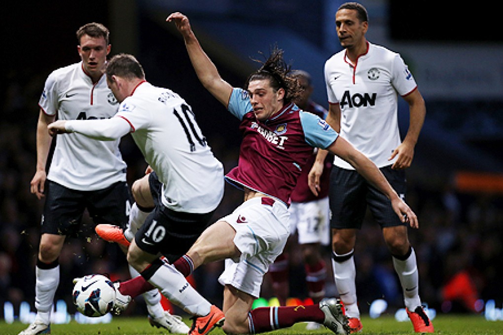West Ham's Andy Carroll (centre) competes for the ball with Manchester United's Wayne Rooney. Photo: AP