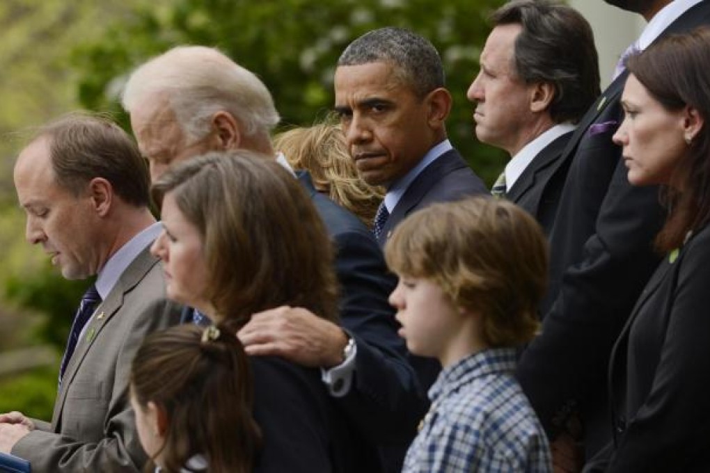 Barack Obama with the families of shooting victims. Photo: EPA