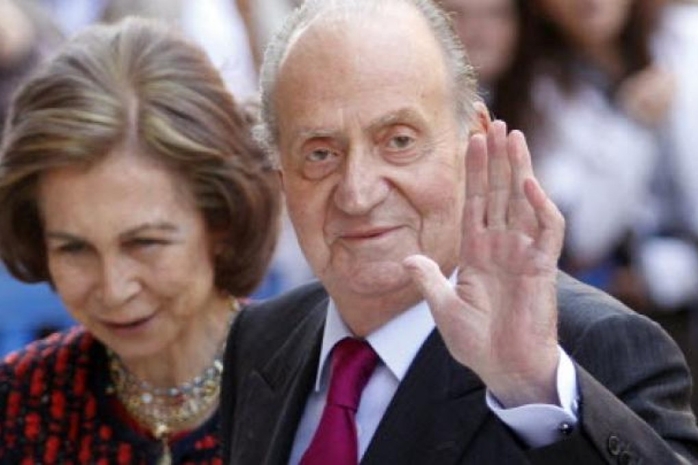 Spain's King Juan Carlos (right) waves beside Queen Sofia. Photo: Reuters