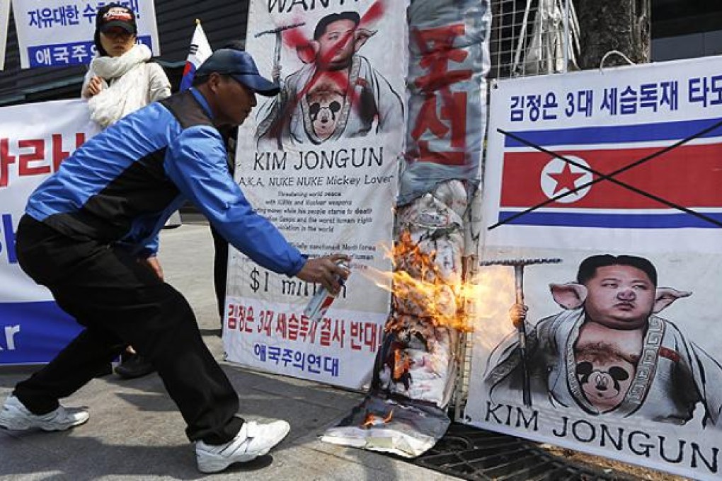 A protester burns a picture of North Korean leader Kim Jong-un in Seoul. Photo: AP