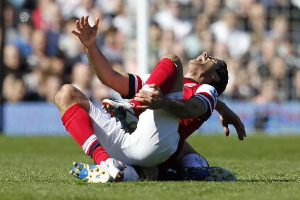 Arsenal's Spanish midfielder Mikel Arteta reacts after a foul from Fulham's English midfielder Steve Sidwell. Photo: AFP