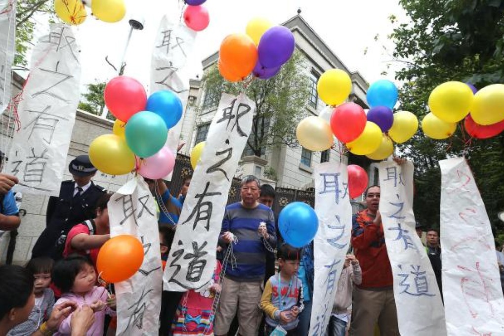 Dockers and their relatives release balloons as they protest outside Li Ka-shing's home in Deep Water Bay yesterday. Photo: Sam Tsang