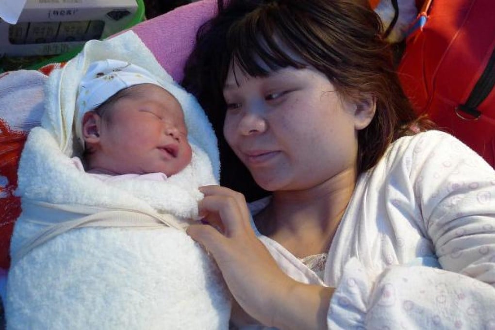 A mother with her new-born baby, who was delivered in an ambulance, in Yaan, Sichuan. Photo: Xinhua