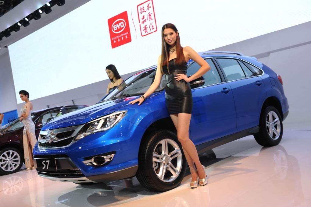 A model poses next to a BYD S7 SUV on media day at the Shanghai auto show on April 20, 2013. Photo: AFP