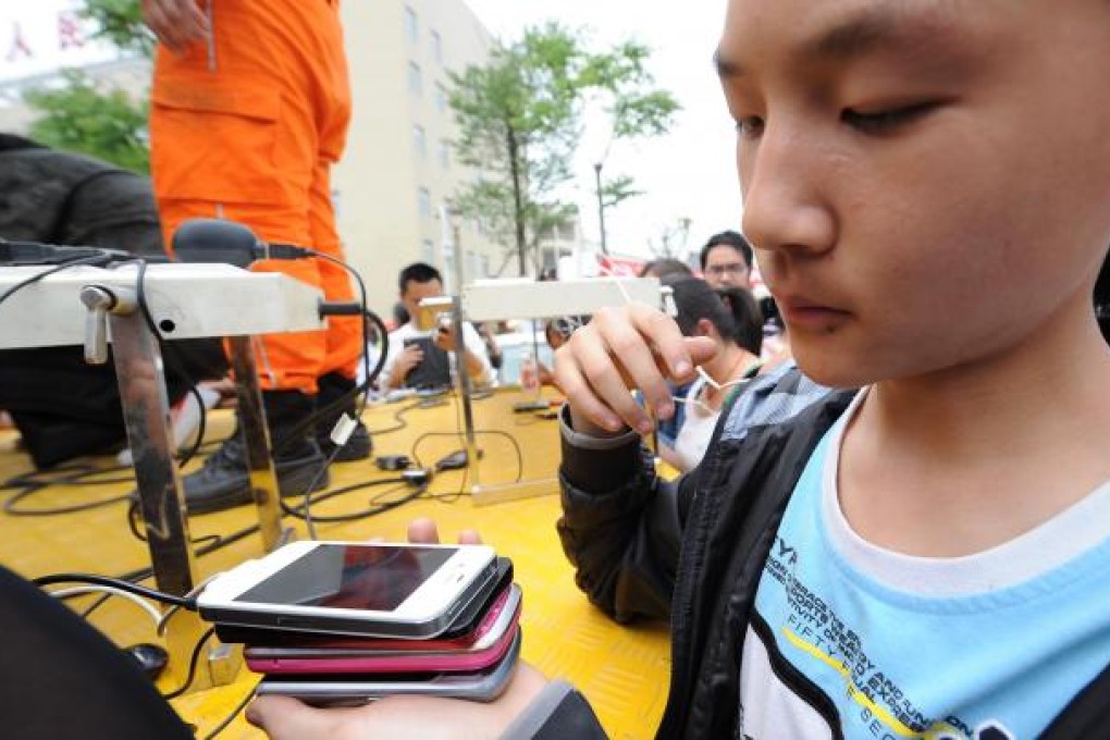 A girl recharges four mobile phones at a time in Yaan, Sichuan, on Sunday. Photo: Xinhua