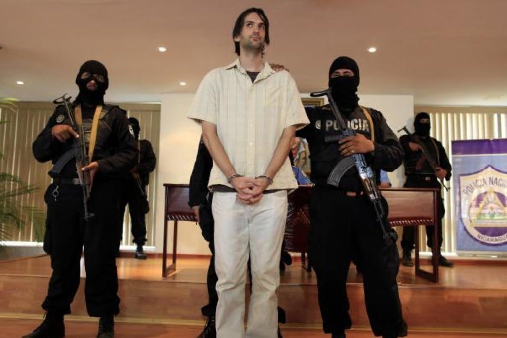 Armed police stand guard as Eric Toth is presented to the media at the police headquarters in Managua, Nicaragua. Photo: Reuters