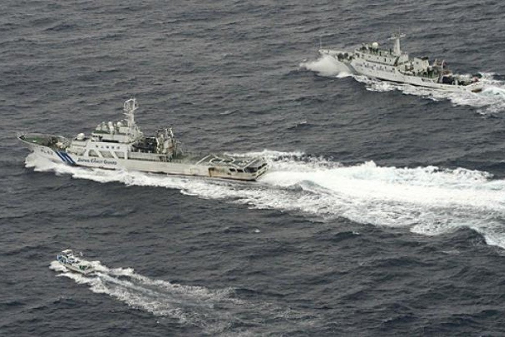 A Chinese marine surveillance ship Haijian No 66 (top) approaches a Japanese fishing boat (bottom) as Japan Coast Guard vessel Ishigaki cruises nearby in the East China Sea. Photo: Reuters