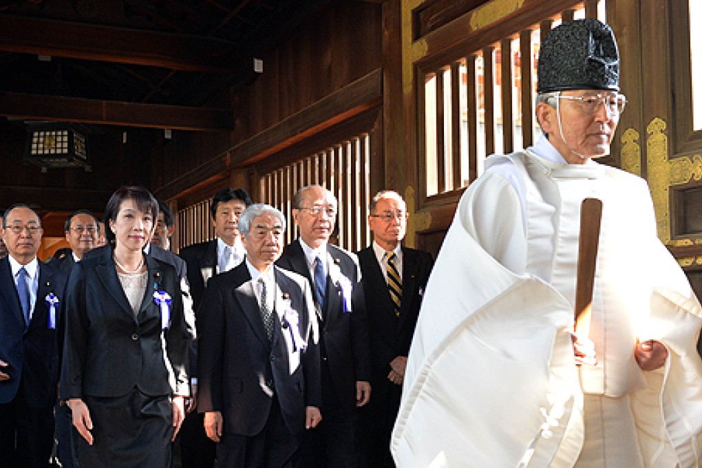 A Shinto priest leads a group of Japanese lawmakers to offer prayers for the war dead at the controversial Yasukuni Shrine in Tokyo on Tuesday. Photo: AFP