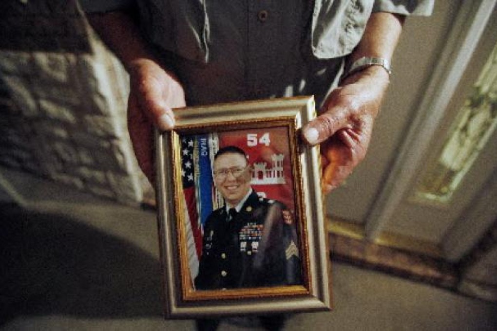 Wilburn Russell displays a portrait of his son, the Army sergeant who is accused of killing five fellow soldiers in Iraq. Photo: Reuters