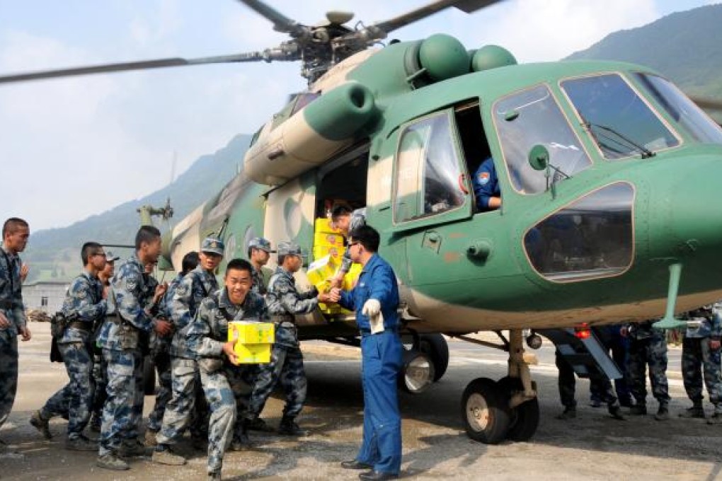 Rescuers carry food off a helicopter in quake-hit Lushan County, Sichuan Province on April 22, 2013. Photo: Xinhua