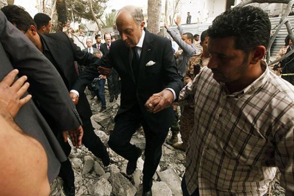 French Foreign Minister Laurent Fabius visits damaged houses around the French embassy in Tripoli. Photo: Reuters
