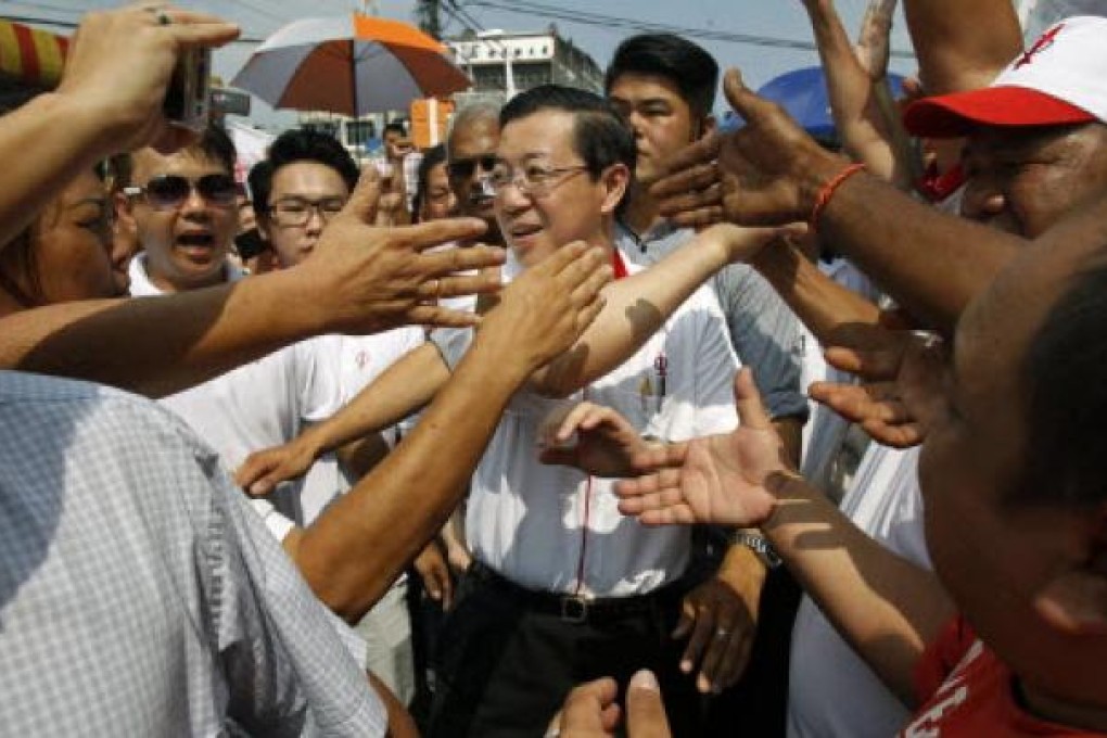 Chief Minister of Penang state Lim Guan Eng (centre) is welcomed by supporters as he arrives for an election campaign rally in Klang, outside Kuala Lumpur on Wednesday. Police says election violence is falling.