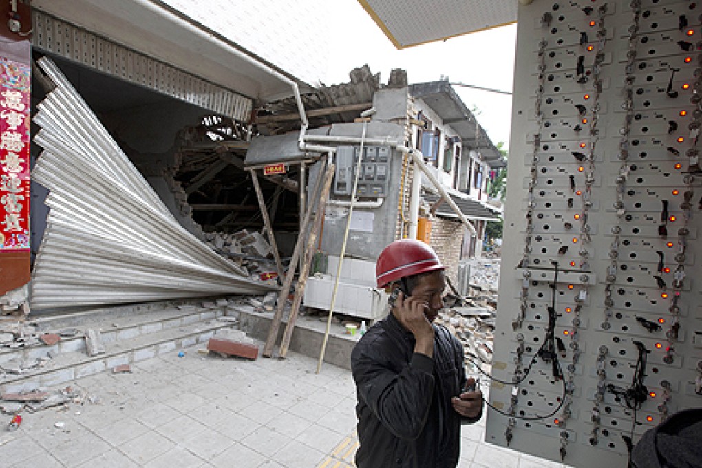 A Chinese man uses a charging facility as he talks on his mobile in Lushan county. Photo: AP