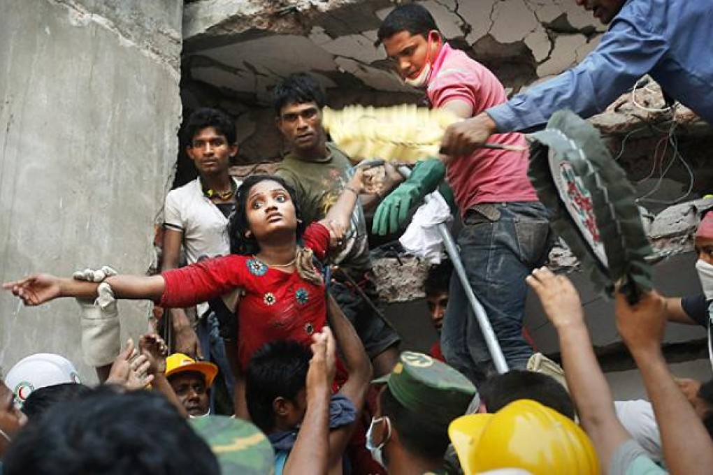 A survivor is lifted out of the rubble by rescuers at the site where a garment factory that collapsed in Savar. Photo: AP
