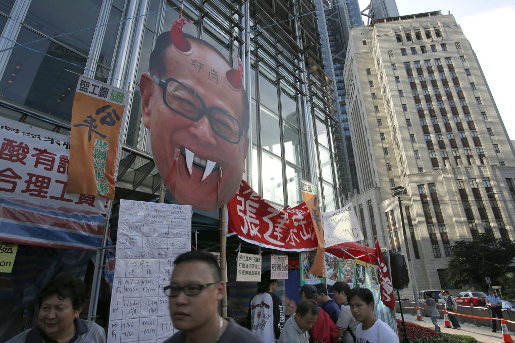 A defaced portrait of Hong Kong billionaire Li Ka-shing is placed outside Cheung Kong Centre. Photo: AP