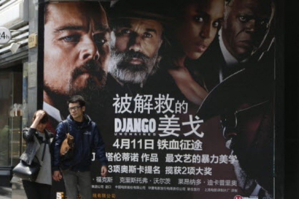 A Chinese couple walk past a movie poster of US movie 'Django Unchained' in Shanghai, China, 12 April 2013. Photo: EPA