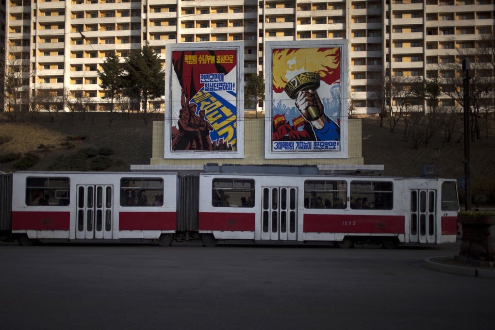 Pyongyang commuters ride on a trolleybus as it passes propaganda posters. Photo: AP
