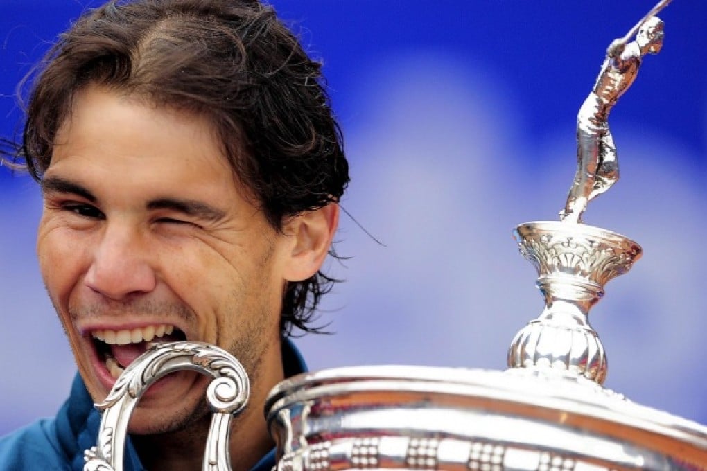 Rafa Nadal bites his trophy as he celebrates his victory. Photo: AFP