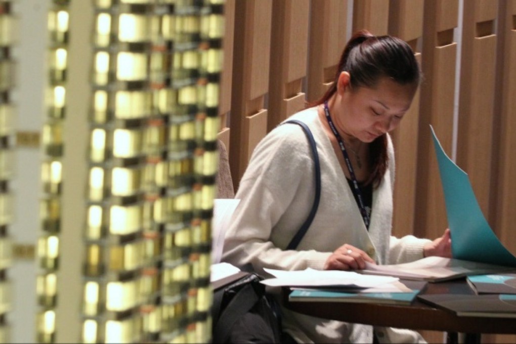 Potential buyers browse the sales brochure of Hong Kong Ferry's Green Code residential project in Fanling. Photo: Nora Tam