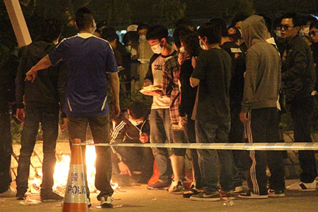 About 60 people staged a vigil, burning incense and offering prayers, at the scene of Tse's attack on Sunday night. Photo: SCMP