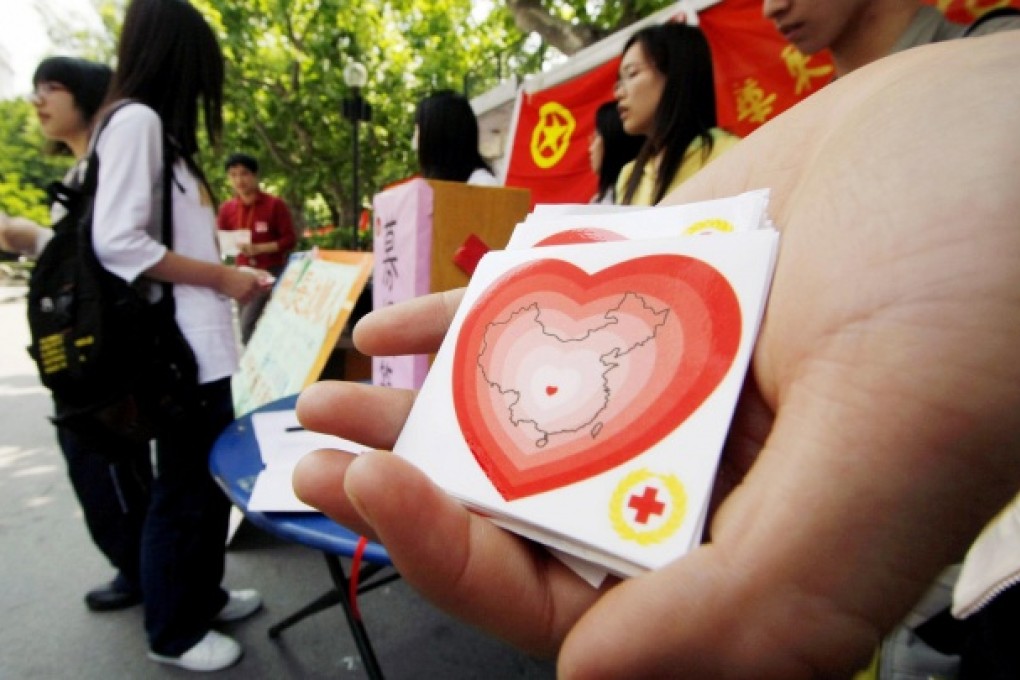 Students distribute Red Cross stickers in Shanghai. Photo: AP