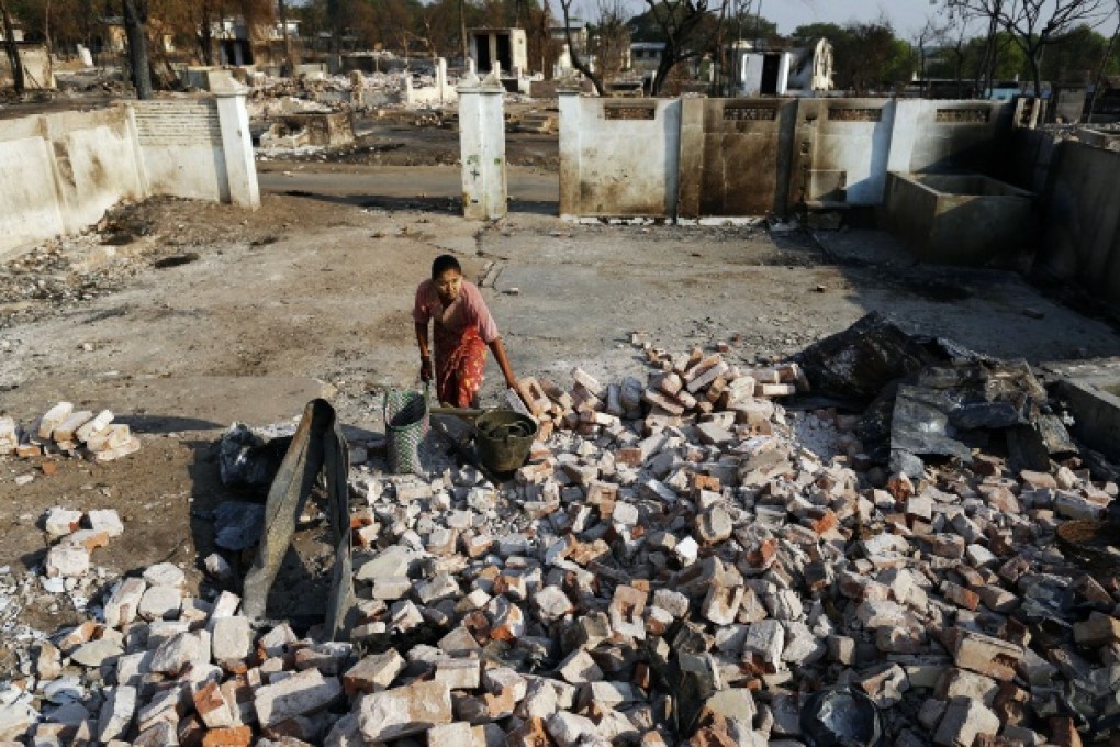 A woman collects bricks and other useful items from burnt Muslim homes in Meikhtila. Photo: Reuters