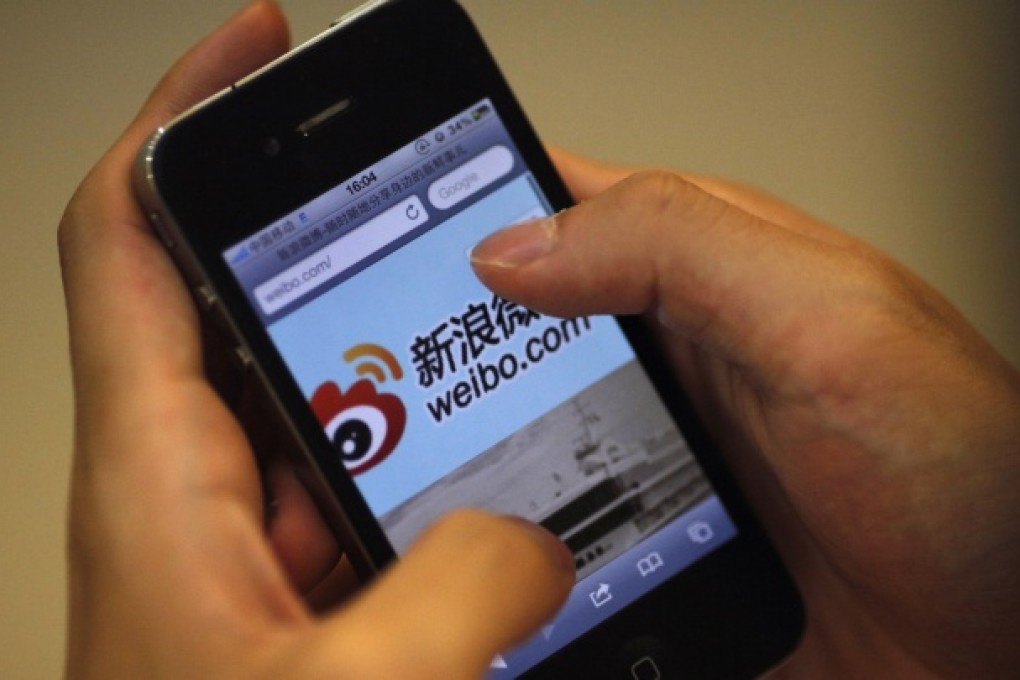 A man holds an iPhone as he visits Sina's Weibo microblogging site in Shanghai. Photo: Reuters