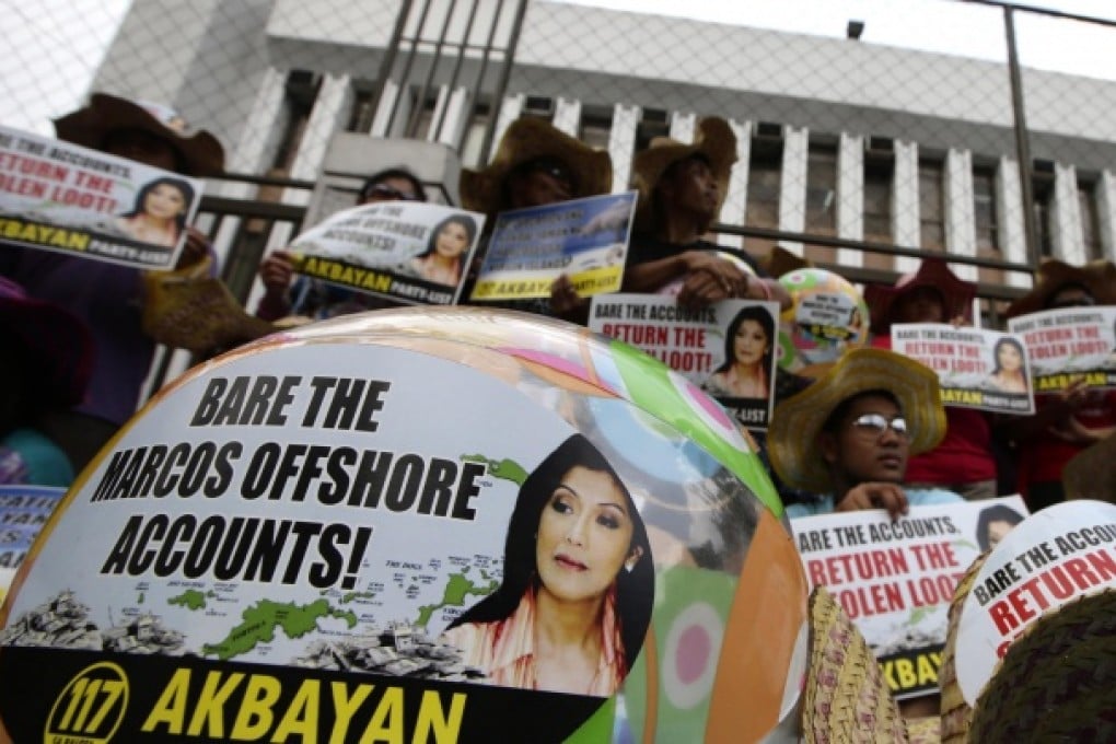 Protesters holding banners bearing the face of Ferdinand and Imelda Marcos' daughter Imee demand action on the former first family's offshore accounts during a protest in Manila on April 8. Photos: AFP; AP; Reuters