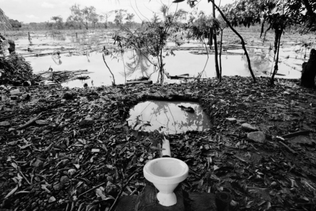 A sewage pit fills with floodwater near an open toilet in Baracoa, Honduras. Photos; AFP; Corbis; EPA