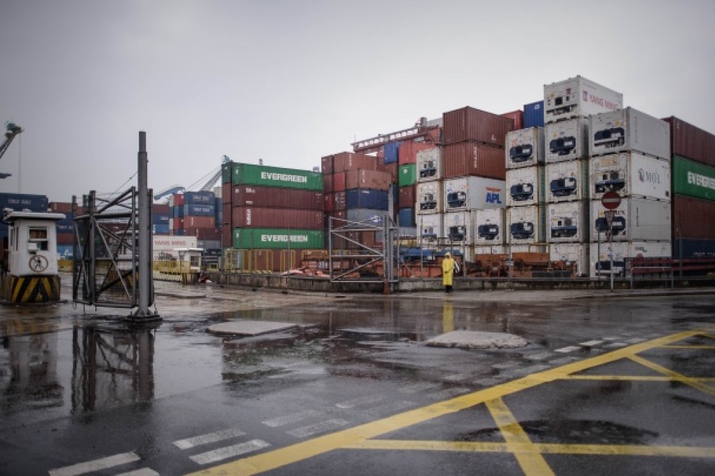 A security guard keeps vigil in front of containers as dockers continue their strike. Photo: AFP