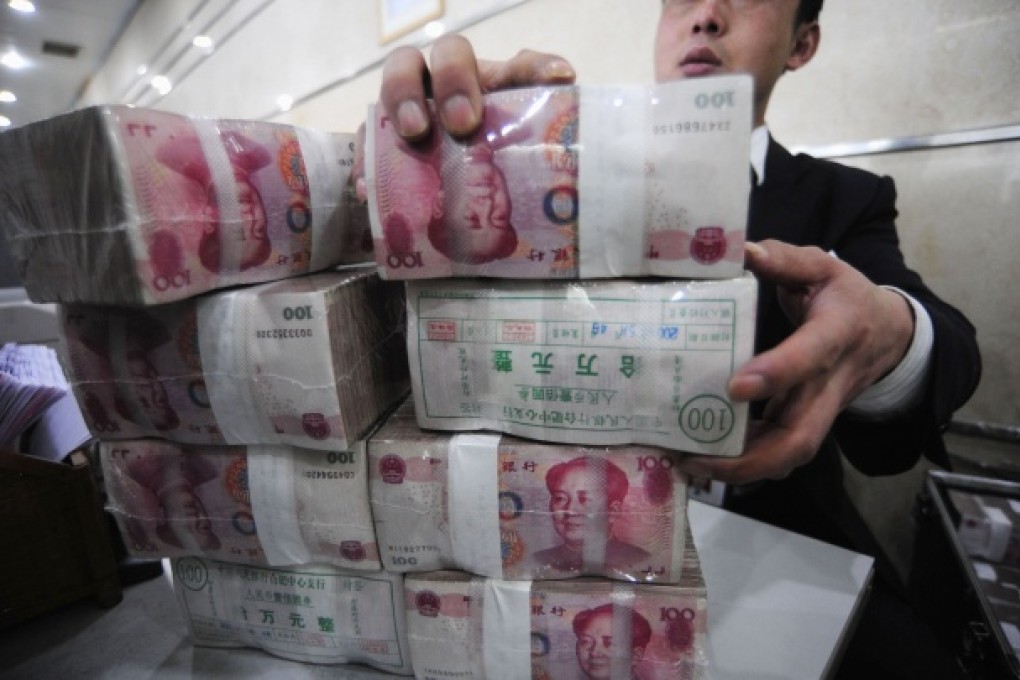 An employee packs bundles of Renminbi banknotes at a branch of the Bank of China. Photo: Reuters