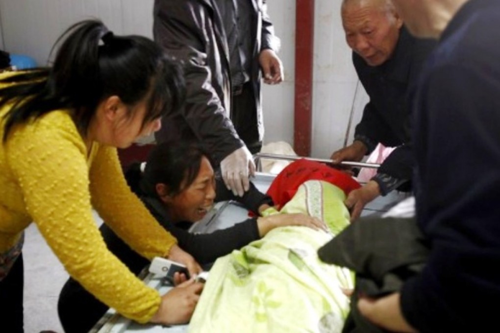 Family members at the bedside of one of the girls who died in hospital after drinking yogurt containing rat poison. Photo: SCMP Pictures