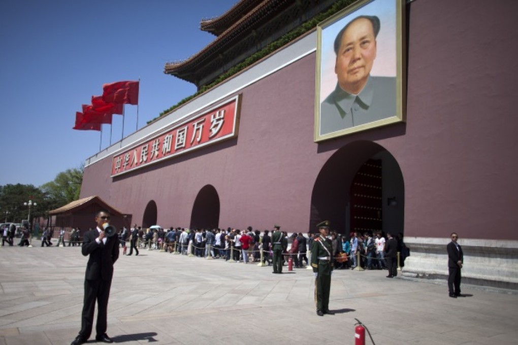 Paramilitary policemen, in uniforms and plainclothes, guard with fire extinguishers while tourists walk out of an entrance in front of Tiananmen Gate in Beijing. Photo: AP