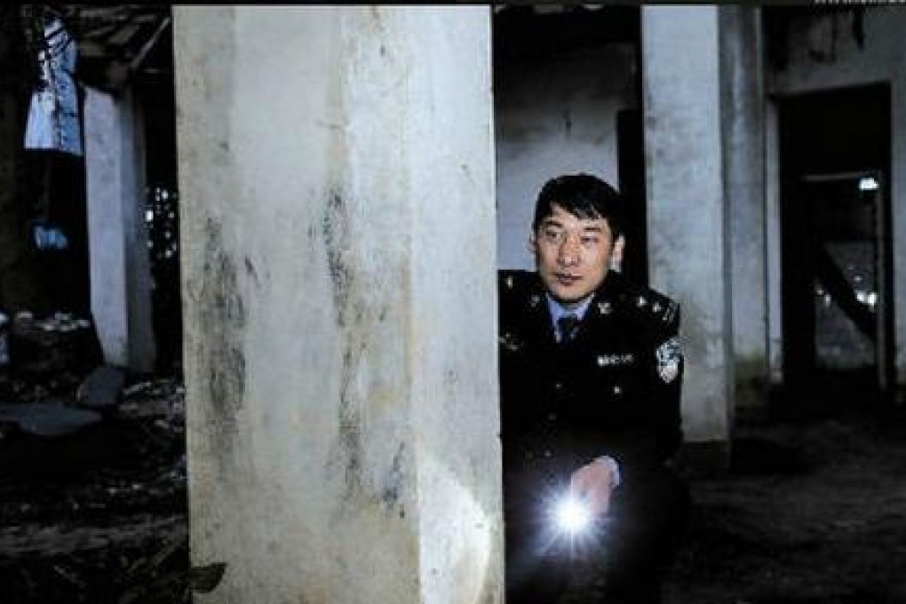 A police officer navigates the 'haunted house'. Photo: Screenshot via Sina Weibo