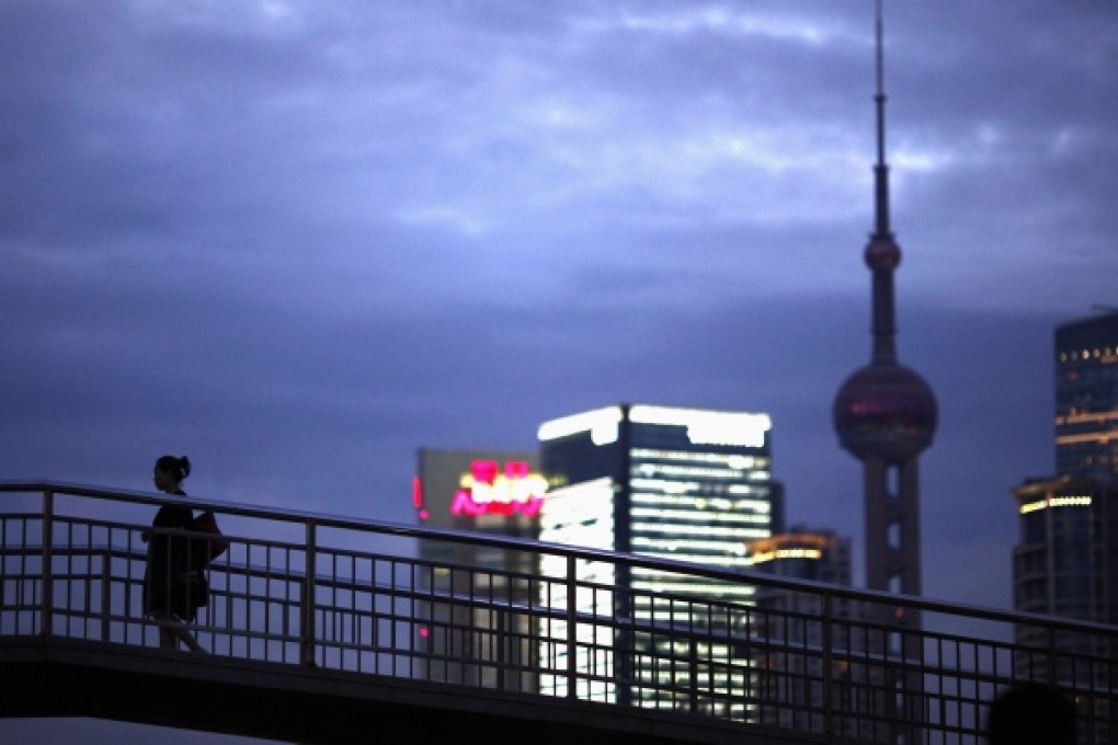 A woman walks along a overhead bridge near Shanghai's financial district of Pudong August 24, 2012. Photo: Reuters