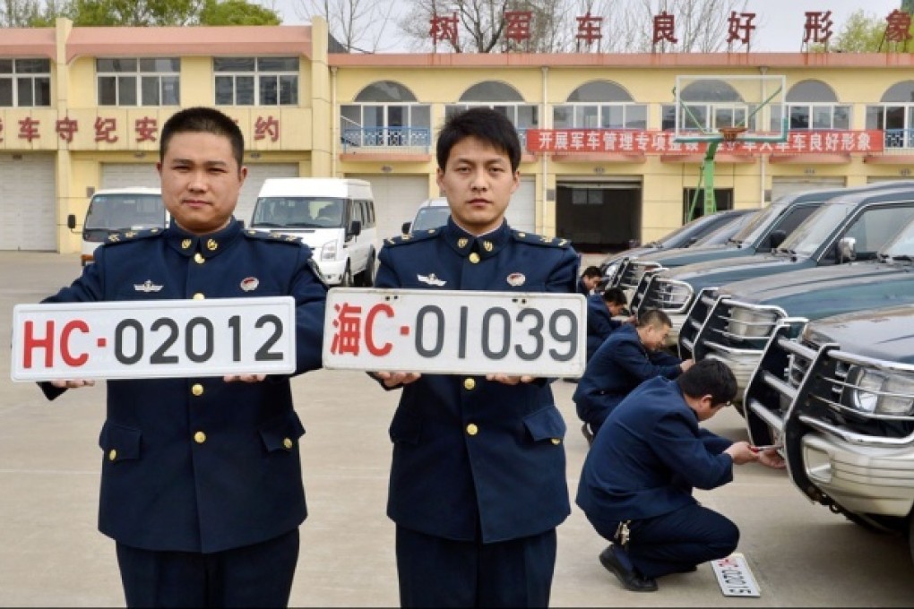 Soldiers at a People's Liberation Army unit in Qinhuangdao, Hebei province, display new and old military vehicle licence plates. Photo: Xinhua
