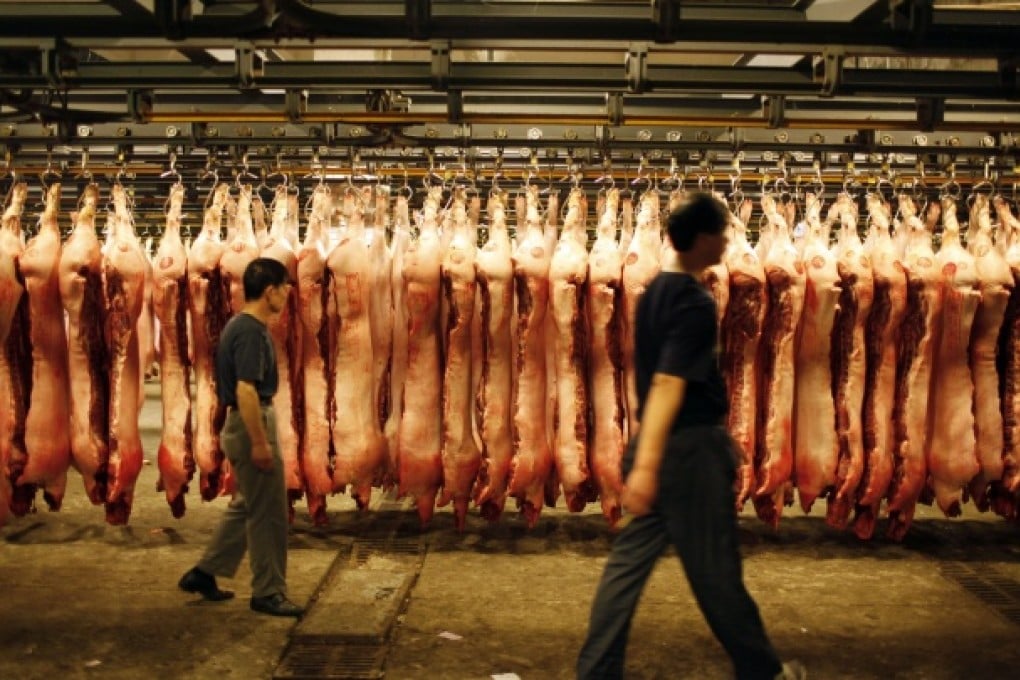 Buyers select pig carcasses to purchase for the morning food markets at a wholesale centre on the outskirts of Shanghai. Photo: EPA