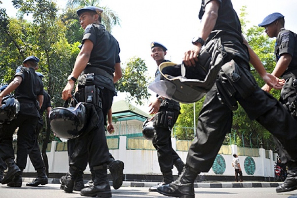 Indonesian police arrive at the Myanmar embassy in Jakarta on Friday as part of their efforts to secure the embassy from Muslim protesters expected to carry out anti-Buddhist demonstrations. Photo: AFP